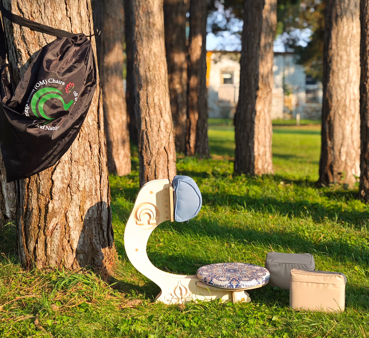 OM Chair components displayed outdoors — wooden meditation chair frame with blue cushion pads and carry bag
